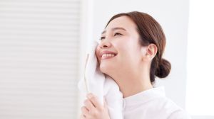 Woman holding a hot towel to her face